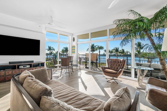 sunroom / solarium featuring ceiling fan and a water view