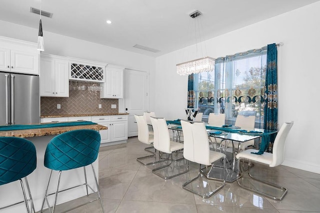 dining area featuring light tile patterned floors and a notable chandelier