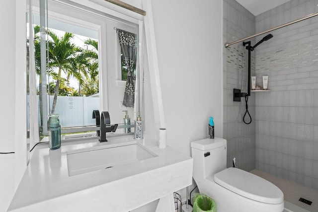 bathroom featuring tiled shower, vanity, and toilet