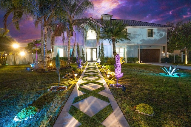 view of front of property with a garage and a yard