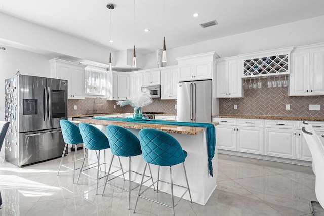 kitchen featuring white cabinetry, hanging light fixtures, a center island, and appliances with stainless steel finishes