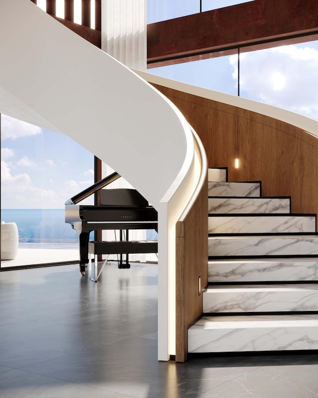 staircase featuring a healthy amount of sunlight and a water view