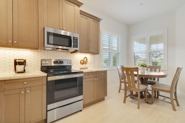 11263 SW Visconti Way, Port Saint Lucie, FL 34986 - kitchen featuring appliances with stainless steel finishes, tasteful backsplash, and light stone counters