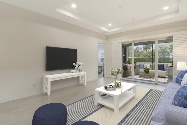 living room with light hardwood / wood-style floors and a raised ceiling