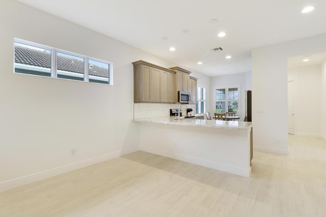 11263 SW Visconti Way, Port Saint Lucie, FL 34986 - kitchen with stainless steel microwave, recessed lighting, light wood-style flooring, tasteful backsplash, and range