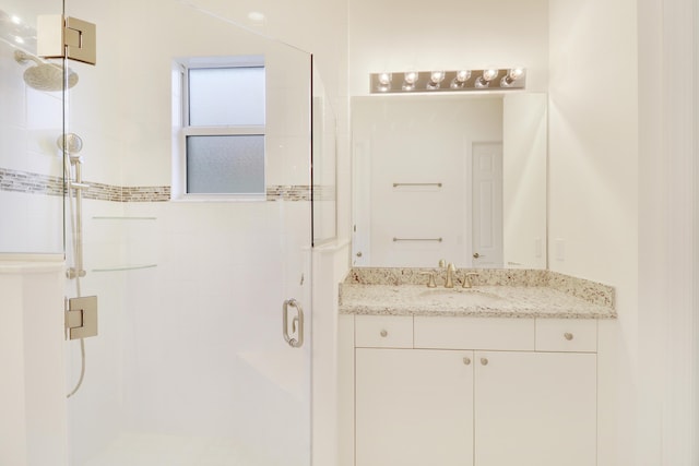 bathroom featuring vanity and a shower with door