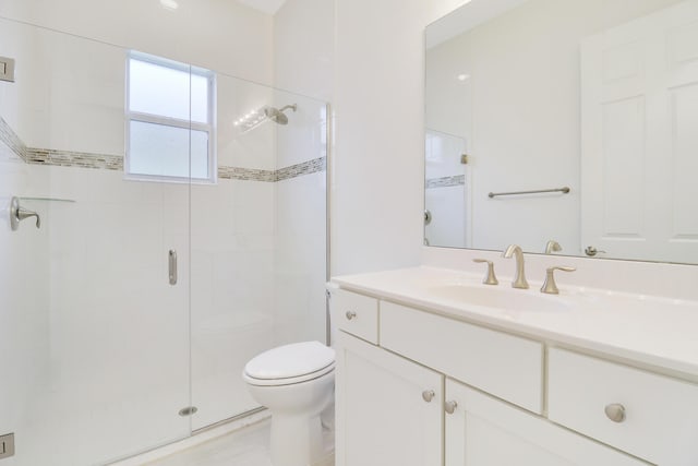 bathroom with walk in shower, vanity, and toilet