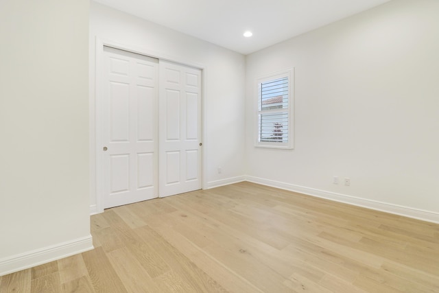 unfurnished bedroom with light hardwood / wood-style flooring and a closet