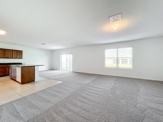 kitchen featuring light colored carpet, white dishwasher, a center island with sink, and sink