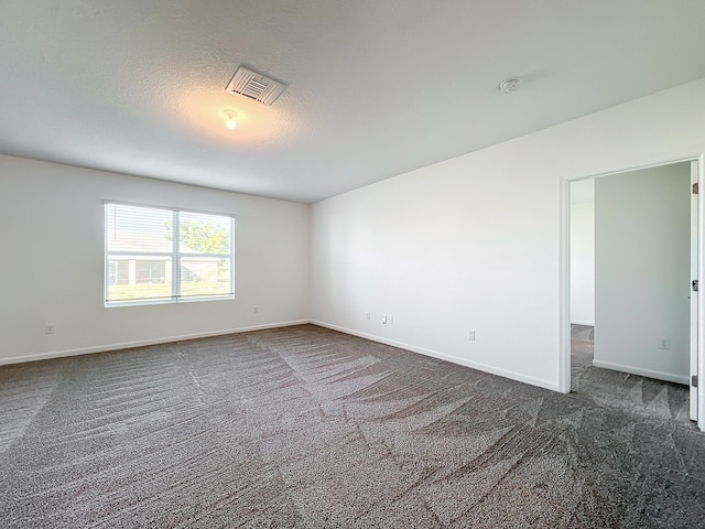 carpeted spare room with a textured ceiling