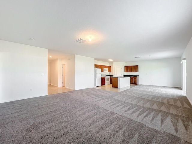 unfurnished living room featuring light carpet