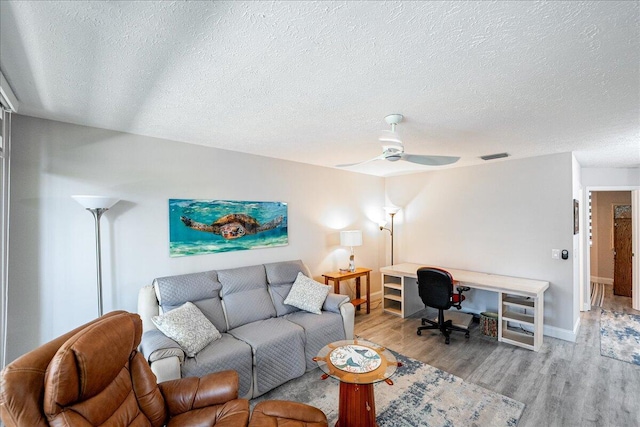 1806 SE Hideaway Cir Unit 1806, Port Saint Lucie, FL 34952 - living room featuring a textured ceiling, wood finished floors, an office area, baseboards, and ceiling fan