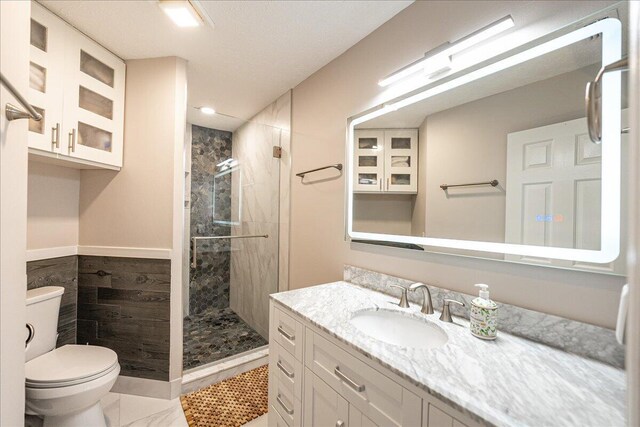 bedroom with a textured ceiling, wood finished floors, visible vents, and baseboards