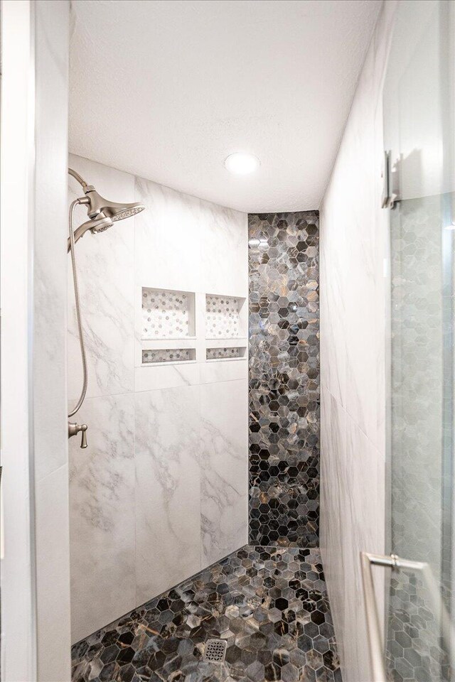 bedroom featuring a ceiling fan, connected bathroom, visible vents, and a textured ceiling