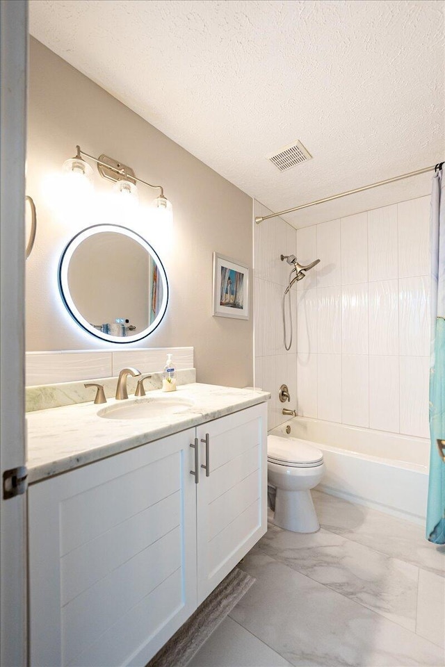 full bath featuring visible vents, shower / tub combo with curtain, marble finish floor, a textured ceiling, and vanity