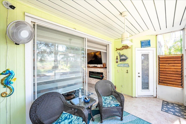 sunroom featuring a glass covered fireplace