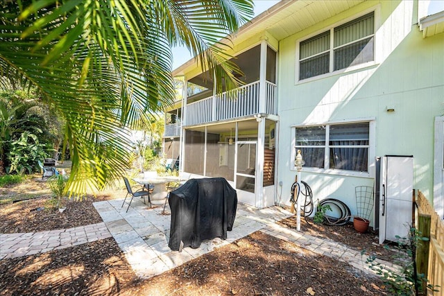 view of patio / terrace with area for grilling, a balcony, and a sunroom