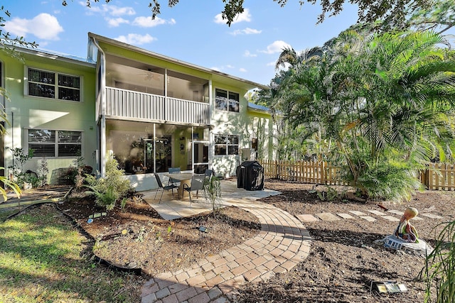 rear view of property with a patio, ceiling fan, a balcony, and fence