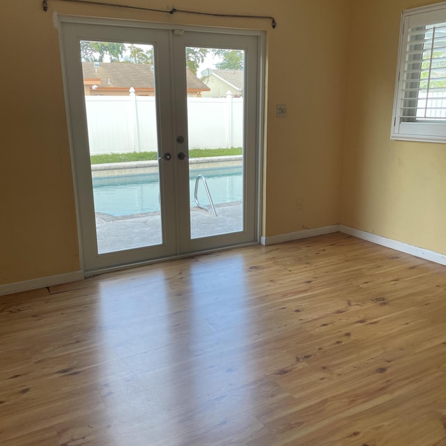 unfurnished room with light hardwood / wood-style floors and french doors