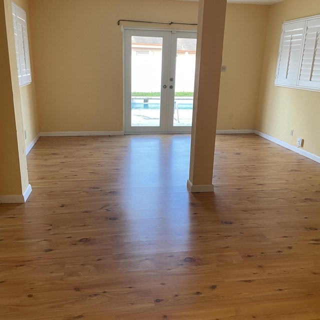 unfurnished room featuring light wood-type flooring and french doors