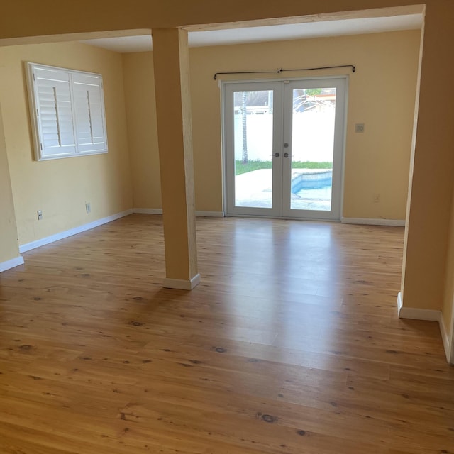 spare room with light hardwood / wood-style flooring and french doors