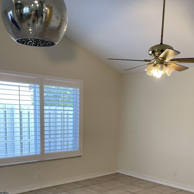 spare room with ceiling fan, lofted ceiling, and light tile patterned floors