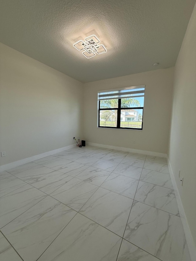 unfurnished room with a textured ceiling