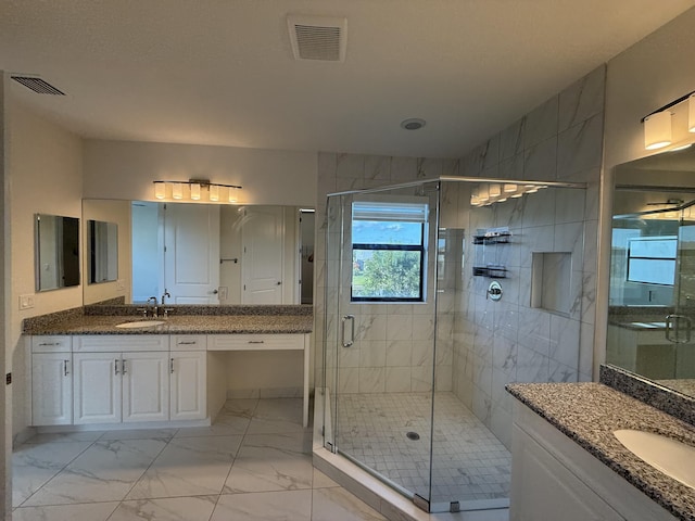 bathroom with a shower with door and vanity