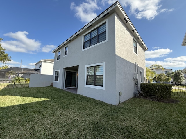 rear view of house featuring a lawn