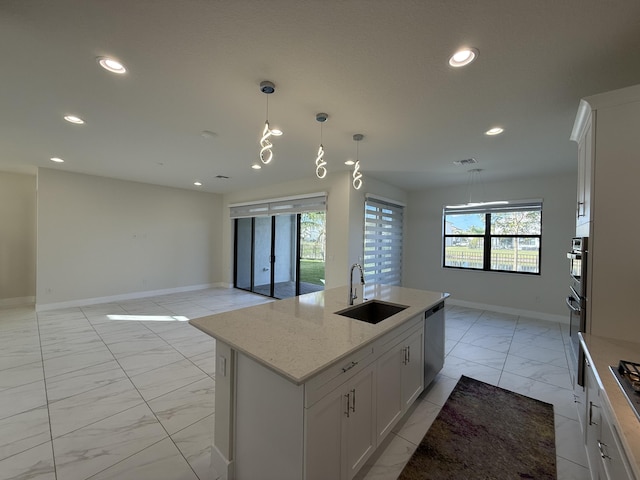 kitchen featuring dishwasher, white cabinets, sink, an island with sink, and light stone counters