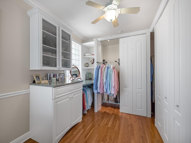 walk in closet featuring light hardwood / wood-style floors and ceiling fan