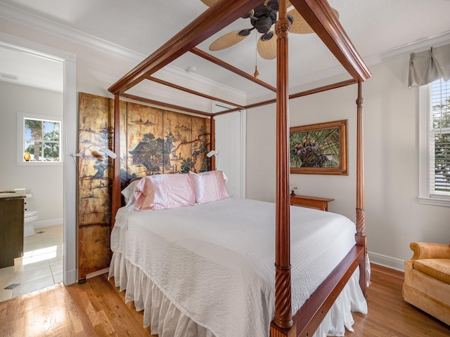 bedroom featuring crown molding, ensuite bath, and light hardwood / wood-style flooring