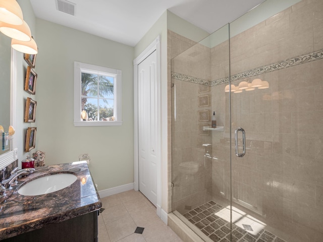 bathroom featuring vanity, an enclosed shower, tile patterned floors, and toilet