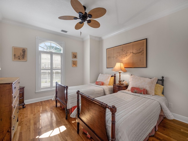 bedroom featuring ceiling fan, ornamental molding, and hardwood / wood-style floors