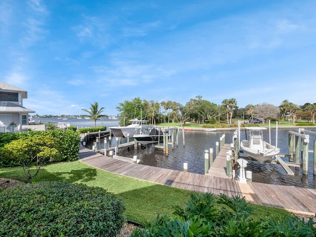 dock area with a water view and a lawn