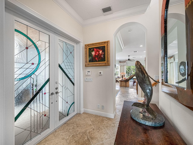 foyer entrance featuring crown molding and french doors