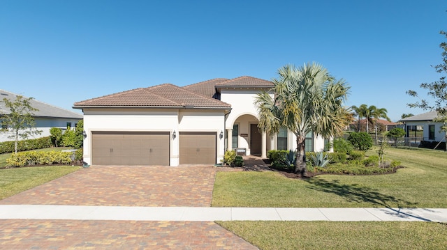 mediterranean / spanish-style house with a front lawn and a garage