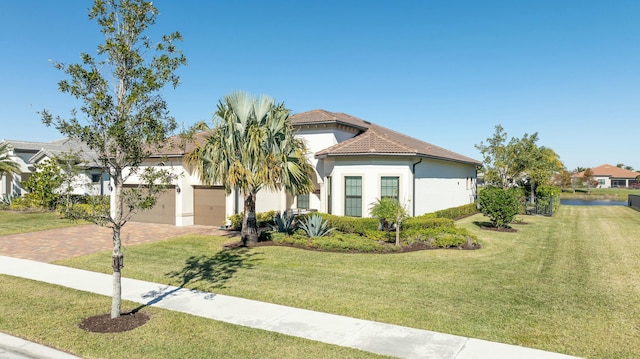 mediterranean / spanish-style home featuring a garage and a front yard