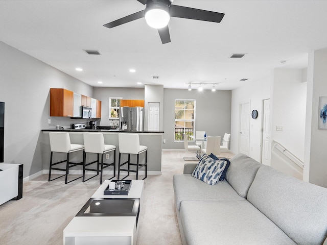 carpeted living room with ceiling fan and rail lighting