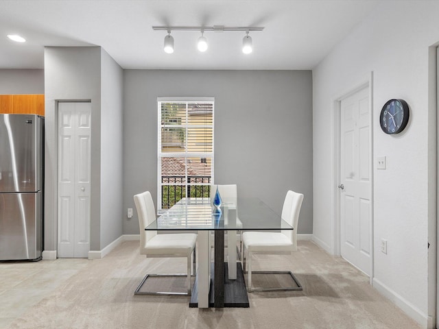 dining space featuring light carpet