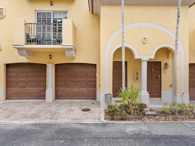 property entrance with a balcony and a garage