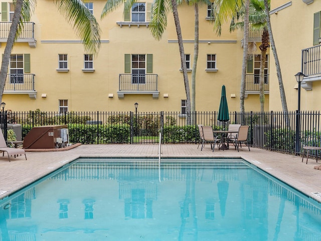 view of swimming pool with cooling unit and a patio area