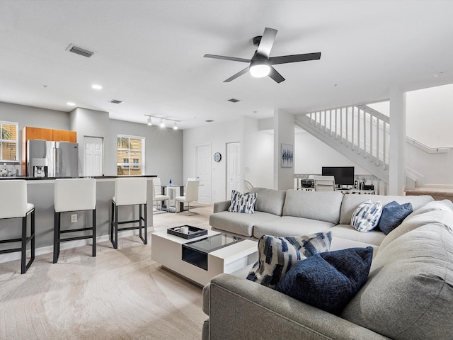 carpeted living room featuring ceiling fan and track lighting