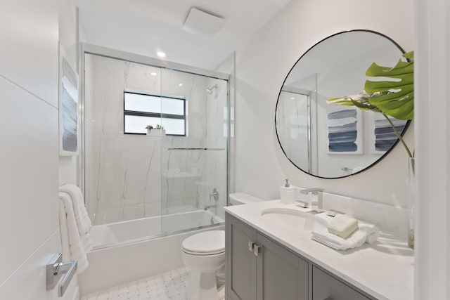 full bathroom with vanity, bath / shower combo with glass door, and toilet