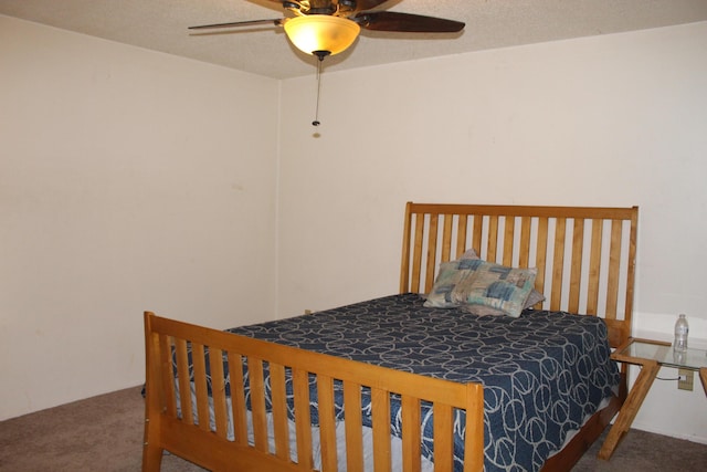 carpeted bedroom with ceiling fan and a textured ceiling