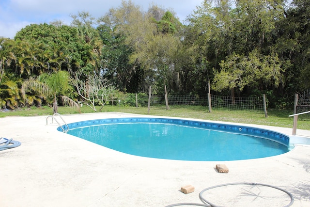 view of pool featuring a patio area, a fenced in pool, fence, and a lawn