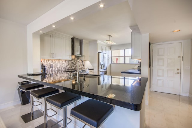 6944 Briarlake Cir Unit 101, Palm Beach Gardens, FL 33418 - kitchen with wall chimney exhaust hood, stainless steel refrigerator with ice dispenser, recessed lighting, dark countertops, and tasteful backsplash