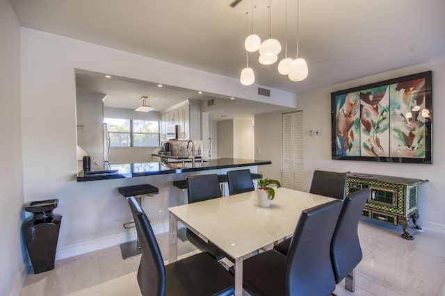 dining area with sink and an inviting chandelier