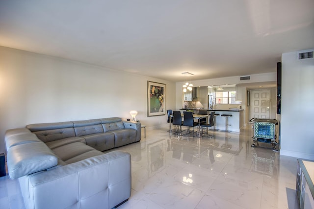 6944 Briarlake Cir Unit 101, Palm Beach Gardens, FL 33418 - living area with light marble finish flooring, a chandelier, and baseboards