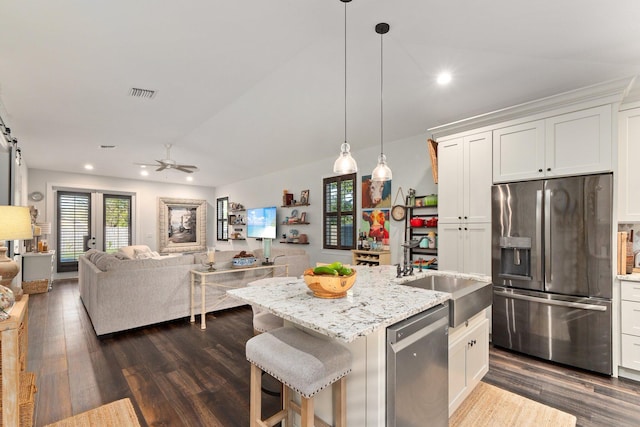 kitchen featuring a kitchen island with sink, white cabinets, stainless steel appliances, and ceiling fan